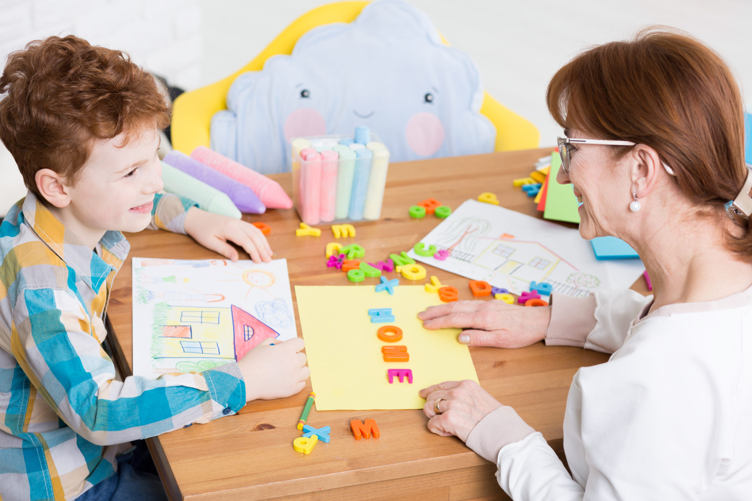 Speech therapist helping young patient to read