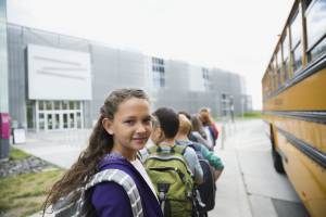 girl next to school bus