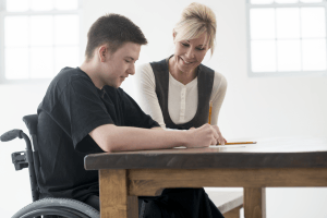 woman helping boy at desk