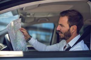 man driving and looking at map