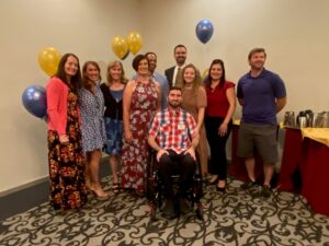 Patient Tyler Moldovan in wheelchair with his RWW therapy team behind him