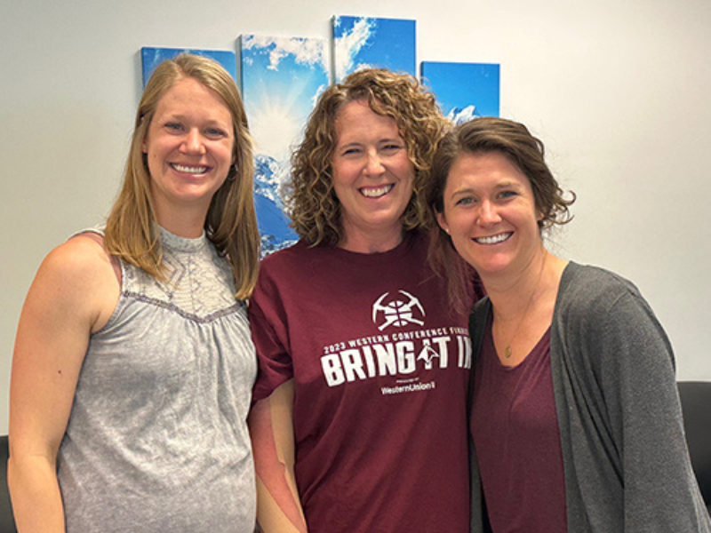 Patient Amy standing with her therapy team.