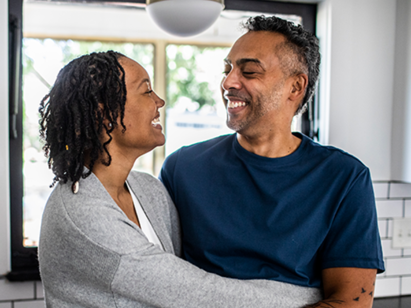 image of man and woman embracing each other in kitchen.