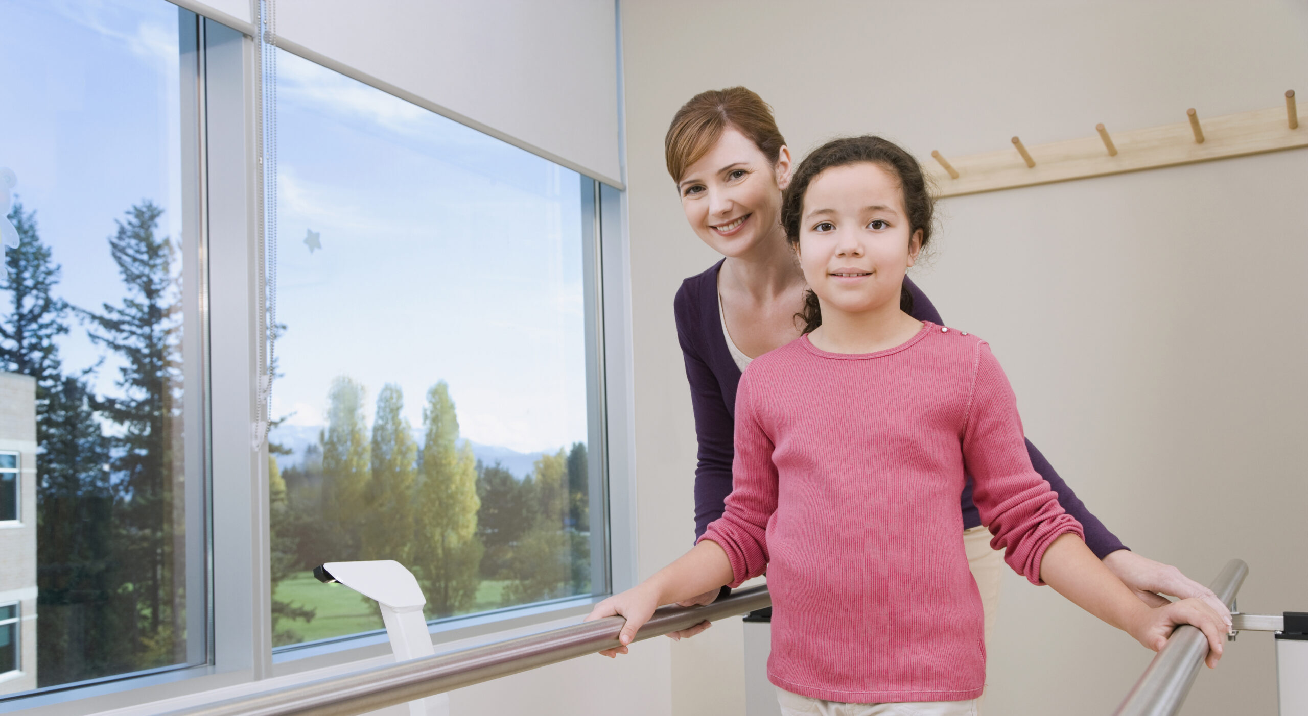 Physical Therapist Helping Girl Walk in Rehabilitation Center