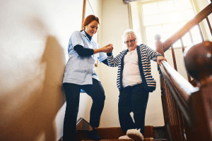 elderly woman on stairs with therapist